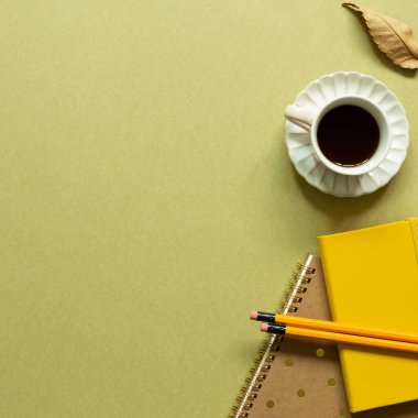 Not defteri, bir fincan kahve, haki renkli kalem. Çalışma alanı. düz alan, üst görünüm, kopyala boşluk