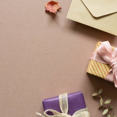 Hediye kutusu, kahverengi arka planda zarf. Yıldönümü, Noel, kutlama konsepti. düz alan, üst görünüm, kopyala boşluk