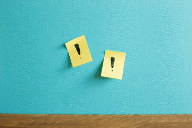 Mavi duvarda ünlem işareti olan yapışkan not defteri. Düşünme, çözüm, iş, fikir kavramı