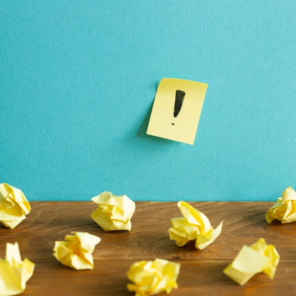 Crumpled Paper Balls Notepad Exclamation Mark Wooden Desk Blue Wall — Stock Photo, Image