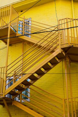 Yellow metal staircase and brick wall building