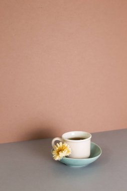 Cup of tea on gray table. brown wall background