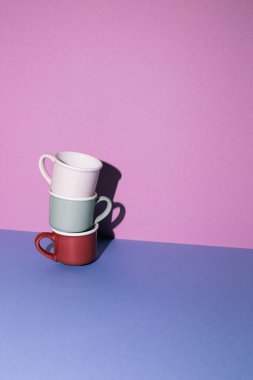 Kupa yığını mavi masada. mor duvar arkaplanı. Boşluğu kopyala