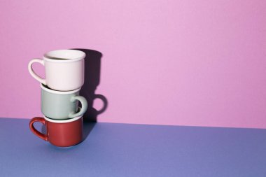 Kupa yığını mavi masada. mor duvar arkaplanı. Boşluğu kopyala