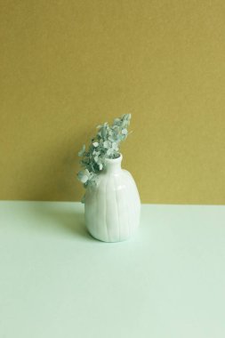 Mavi sehpada kuru ortanca çiçeği vazosu. haki rengi duvar arkaplanı. ev içi