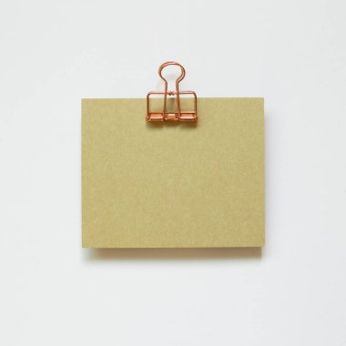 Beyaz arka planda yeşil not defteri ve metal klips izole edildi. Üst görünüm, boşluk kopyala