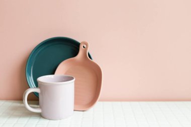 Home kitchen clean dishware on white table. pink wall background