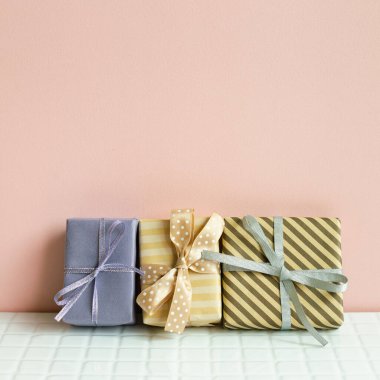 Colorful gift boxes on white table. pink wall background