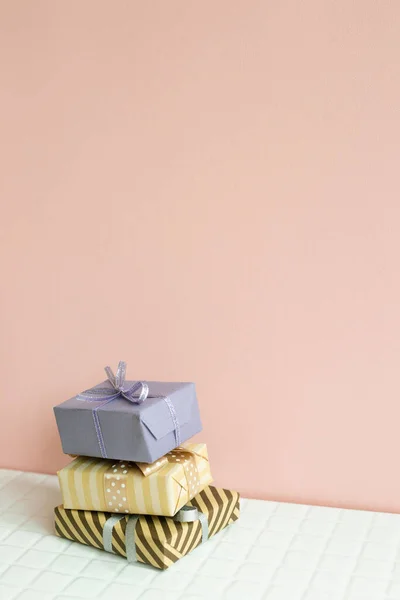 Colorful gift boxes on white table. pink wall background