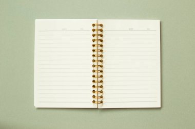 Open note book isolated on green background. top view, copy space