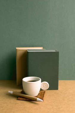 Kahverengi masada defter ve fincan kahve. Yeşil duvar arkaplanı. retro biçimi