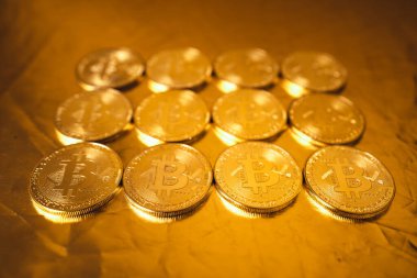Altın zemin üzerinde altın bitcoin, birikmiş bitcoin paralar