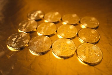 Altın zemin üzerinde altın bitcoin, birikmiş bitcoin paralar