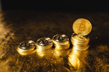 Siyah altın zemin üzerine istiflenmiş bitcoin paraları