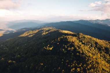 Gün batımında dağların üzerinden bulutlar yükselir.