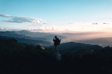 Gün batımında dağların üzerinden bulutlar yükselir.