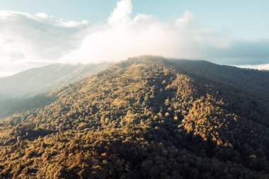 Gün batımında dağların üzerinden bulutlar yükselir.