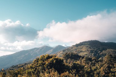 Gün batımında dağların üzerinden bulutlar yükselir.