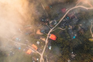 Bulutların üzerinde uçuyor güneş doğuyor ve sis tepede