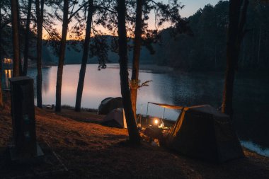 Kamp çadırları, baraj gölleri ve ağaçlar, sabah mavi saati.