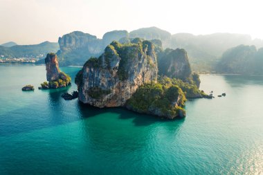 Tropikal bir sabahta kayalık dağların ve denizin yaz manzarası, yengeç.