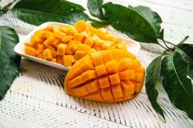 Beyaz ahşap üzerinde taze sarı mango,