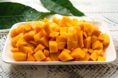 Beyaz ahşap üzerinde taze sarı mango,