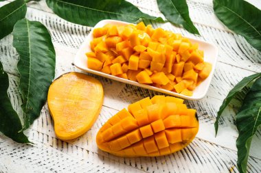 Beyaz ahşap üzerinde taze sarı mango,