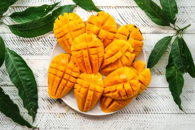 Beyaz ahşap üzerinde taze sarı mango,