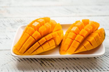 Beyaz ahşap üzerinde taze sarı mango,