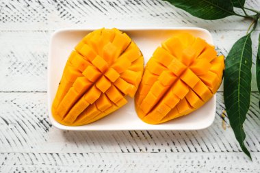 Beyaz ahşap üzerinde taze sarı mango,