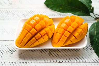 Beyaz ahşap üzerinde taze sarı mango,