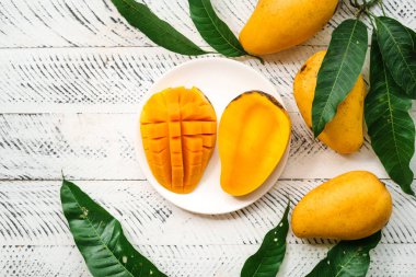 Beyaz ahşap üzerinde taze sarı mango,