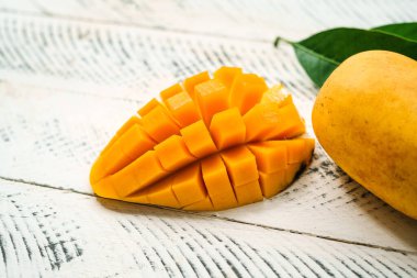 Beyaz ahşap üzerinde taze sarı mango,