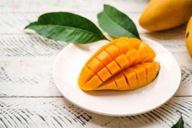 Beyaz ahşap üzerinde taze sarı mango,