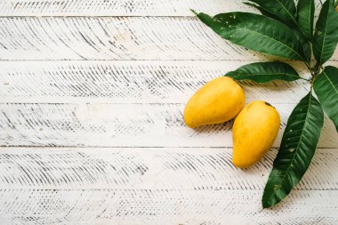 Beyaz ahşap üzerinde taze sarı mango,