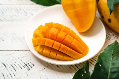 Beyaz ahşap üzerinde taze sarı mango,