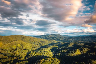Akşamları dağlar ve yeşil ağaçlar.