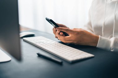 Man working on computer desk and smartphone at home office