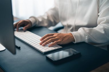 Man working on computer desk and smartphone at home office
