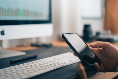 Man working on computer desk and smartphone at home office