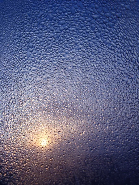 Goccioline d'acqua su vetro e fascio di sole — Foto Stock