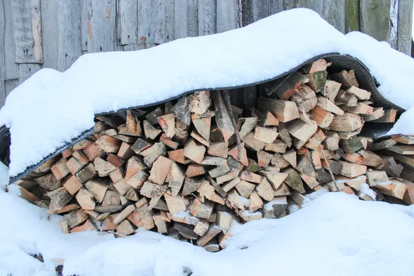 Fire wood combined in heaps under a snow — Stock Photo, Image