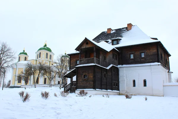 Trähus och vacker kyrka i vinter — Stockfoto