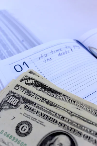 Writing down in a notebook about a debt — Stock Photo, Image