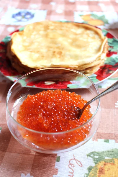 Red caviar in a plate with the spoon — Stock Photo, Image