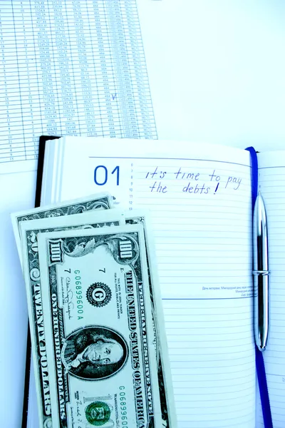 Writing down in a notebook about a debt — Stock Photo, Image