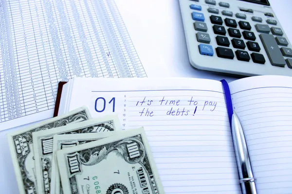 Escribir en un cuaderno sobre una deuda — Foto de Stock