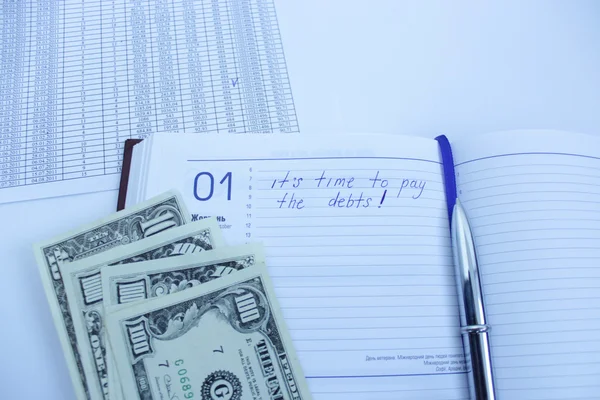 Escribir en un cuaderno sobre una deuda — Foto de Stock