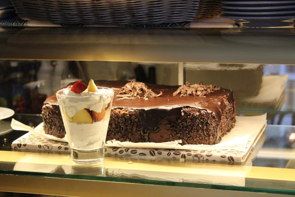 Chocolate cake and ice-cream in the shopwindow — Stock Photo, Image
